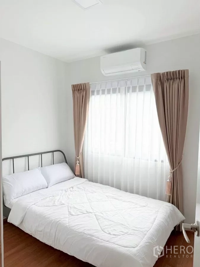 联排别墅 出租在Bang Phli, Samut Prakan - 次卧配金属床架、空调与带窗帘的窗户。
