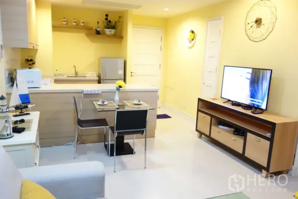 公寓 出租在Khlong Toei, Bangkok - 开放式厨房带吧台，双人餐区与电视柜。