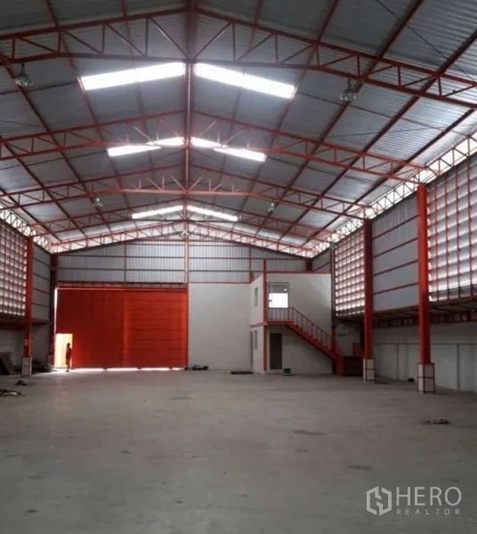 Warehouse for rent in Bang Phli, Samut Prakan - Spacious storage hall facing oversized roller door and mezzanine office