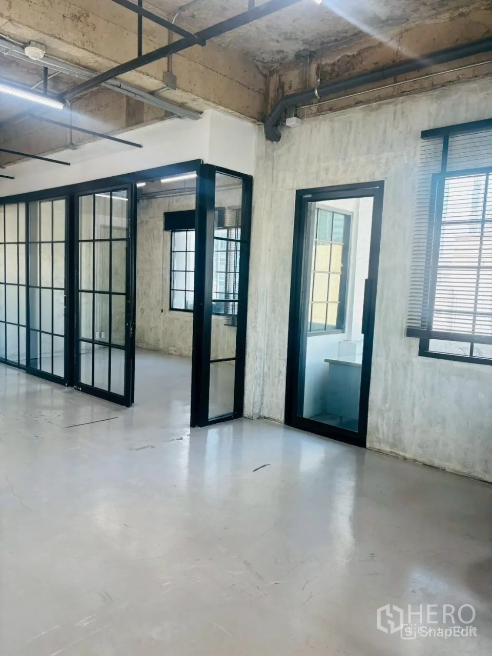 办公空间 出租在Khlong Toei, Bangkok - 走廊设落地玻璃门与百叶窗，通往多个私密房间