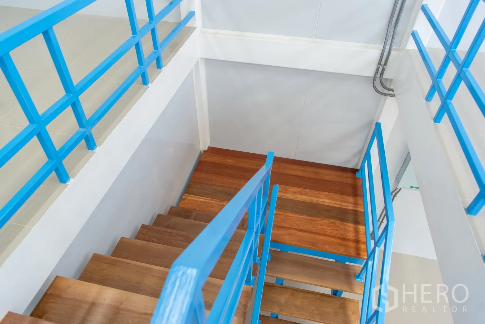 อาคาร standalone for rent or sale in Phra Khanong, Bangkok - บันไดไม้พร้อมราวเหล็กสีน้ำเงินแบบใกล้ชิด