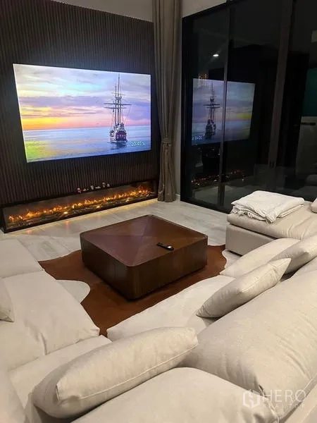Detached House for rent in Saphan Sung, Bangkok - Lounge with large TV, linear fireplace and plush sectional sofa at night.