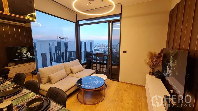 公寓 出租在Watthana, Bangkok - 开放式客餐厅，落地窗与阳台通道。
