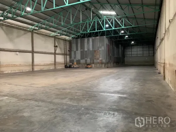 Warehouse for rent in Mueang Pathum Thani, Pathum Thani - Spacious warehouse interior with polished concrete floor and high steel truss ceiling providing a wide clear span.