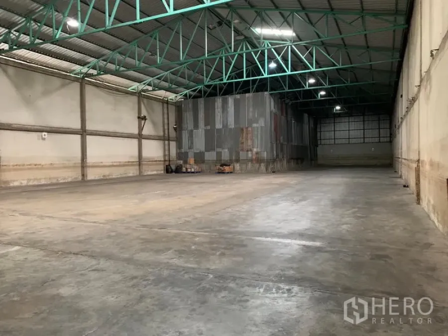 Warehouse for rent in Mueang Pathum Thani, Pathum Thani - Spacious warehouse interior with polished concrete floor and high steel truss ceiling providing a wide clear span.