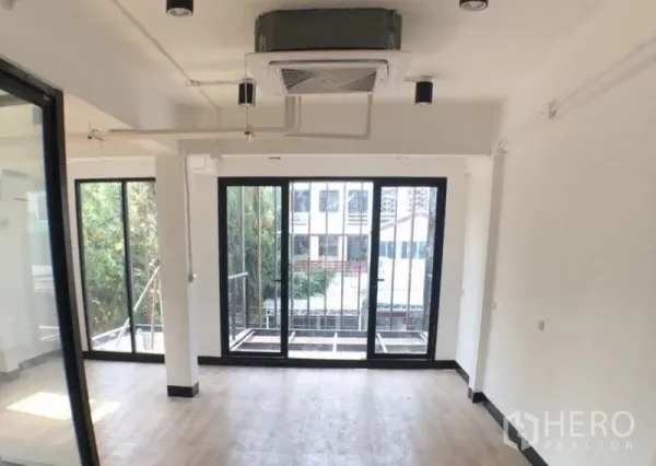 办公空间 出售在Ratchathewi, Bangkok - 转角办公室，推拉玻璃门连通小阳台，吊顶嵌入式空调采光好。