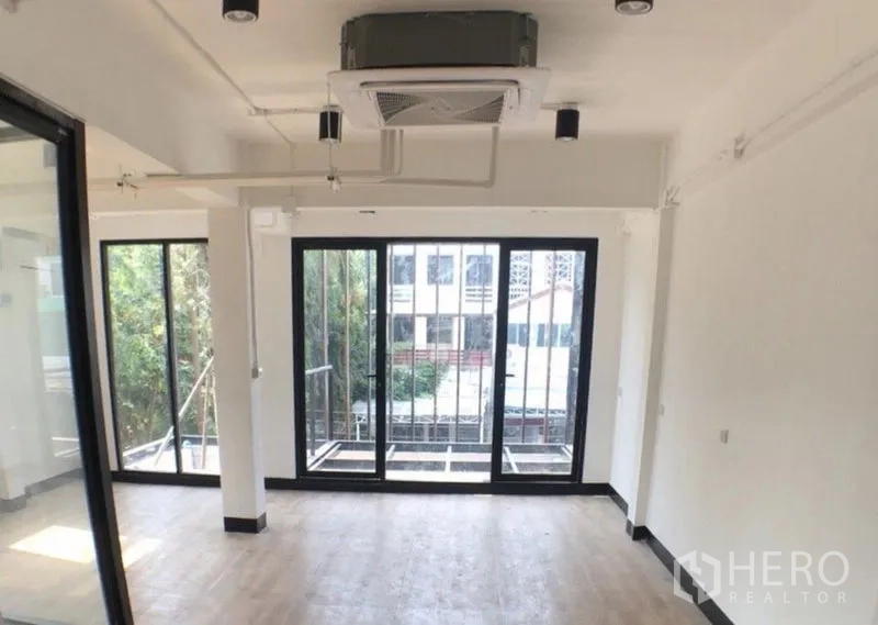办公空间 出售在Ratchathewi, Bangkok - 转角办公室，推拉玻璃门连通小阳台，吊顶嵌入式空调采光好。