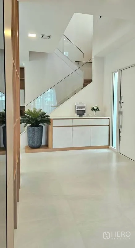 独栋房屋 for rent in Bang Phli, Samut Prakan - 入户玄关，玻璃扶手楼梯与白色收纳柜。