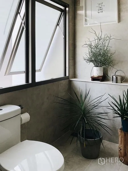 Detached House for sale in Bang Kapi, Bangkok - Guest bathroom with openable windows and potted plants.