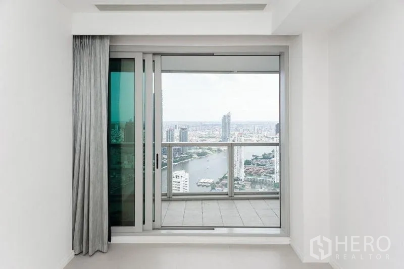 公寓 出售在Khlong San, Bangkok - 推拉玻璃门通往阳台，可眺望河流与城市天际线。