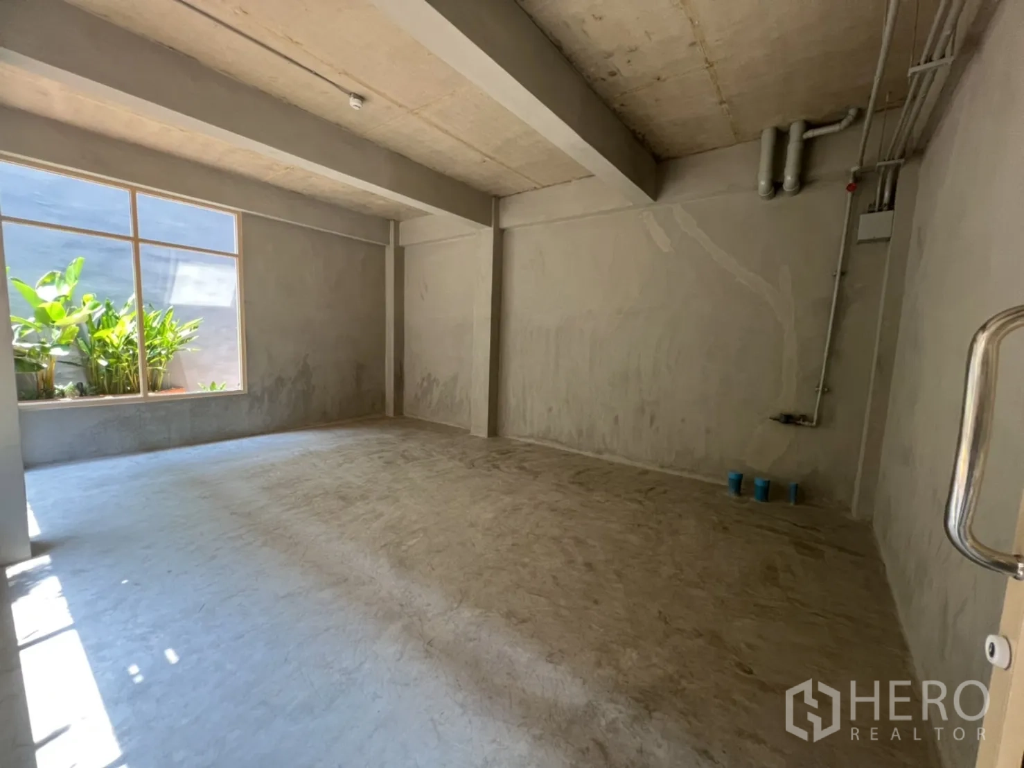 Retail Space for rent in Watthana, Bangkok - Bright shop space with window to greenery and visible plumbing points for future installation.