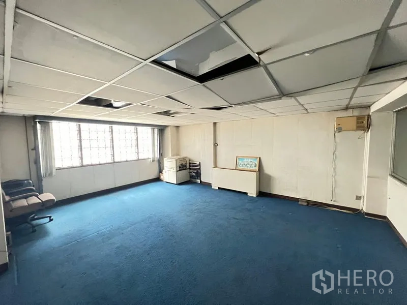Shophouse for sale - Spacious upper-floor room with blue carpet, drop ceiling and wide windows.