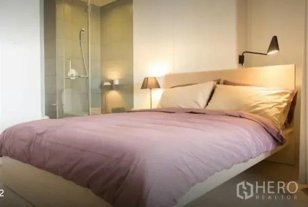 Condominium for rent in Phaya Thai, Bangkok - Primary bedroom with soft lighting and a glass-enclosed shower ensuite.