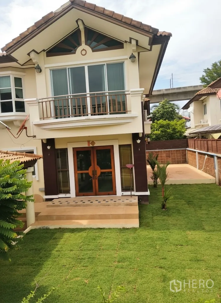 Detached House for rent in Lat Krabang, Bangkok - Rear view of the house with double doors opening to steps and a fresh lawn garden.