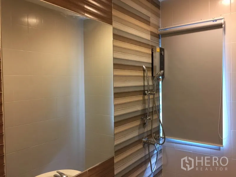 Detached House for rent or sale in Saphan Sung, Bangkok - Bathroom with striped feature wall, large mirror, shower set and roller blind.