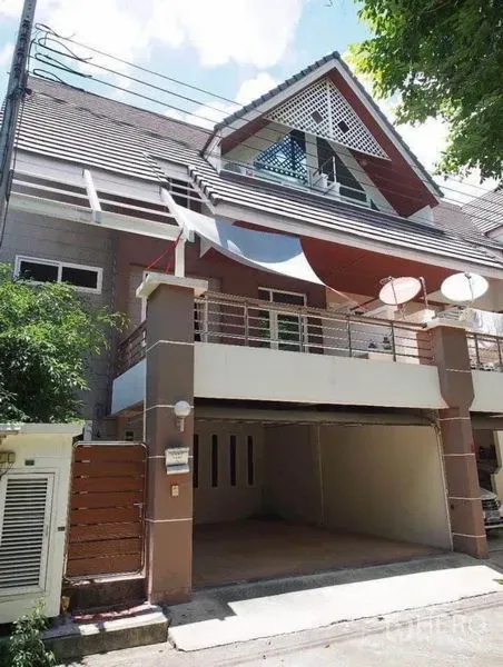 Townhouse for rent in Wang Thonglang, Bangkok - Three-storey townhouse exterior with gabled roof, balcony and covered double carport.
