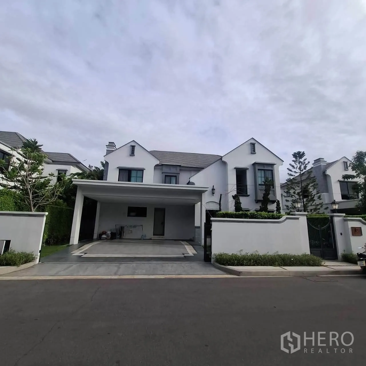 Detached House for rent in Saphan Sung, Bangkok - Contemporary white detached house exterior with gated entrance and covered carport.