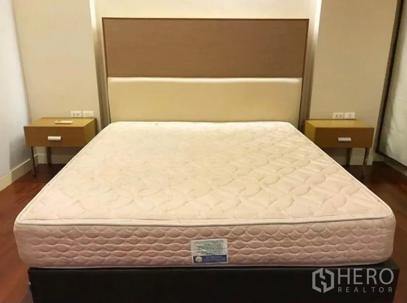 Townhouse for rent in Wang Thonglang, Bangkok - Primary bedroom with large bed, feature headboard and bedside tables.