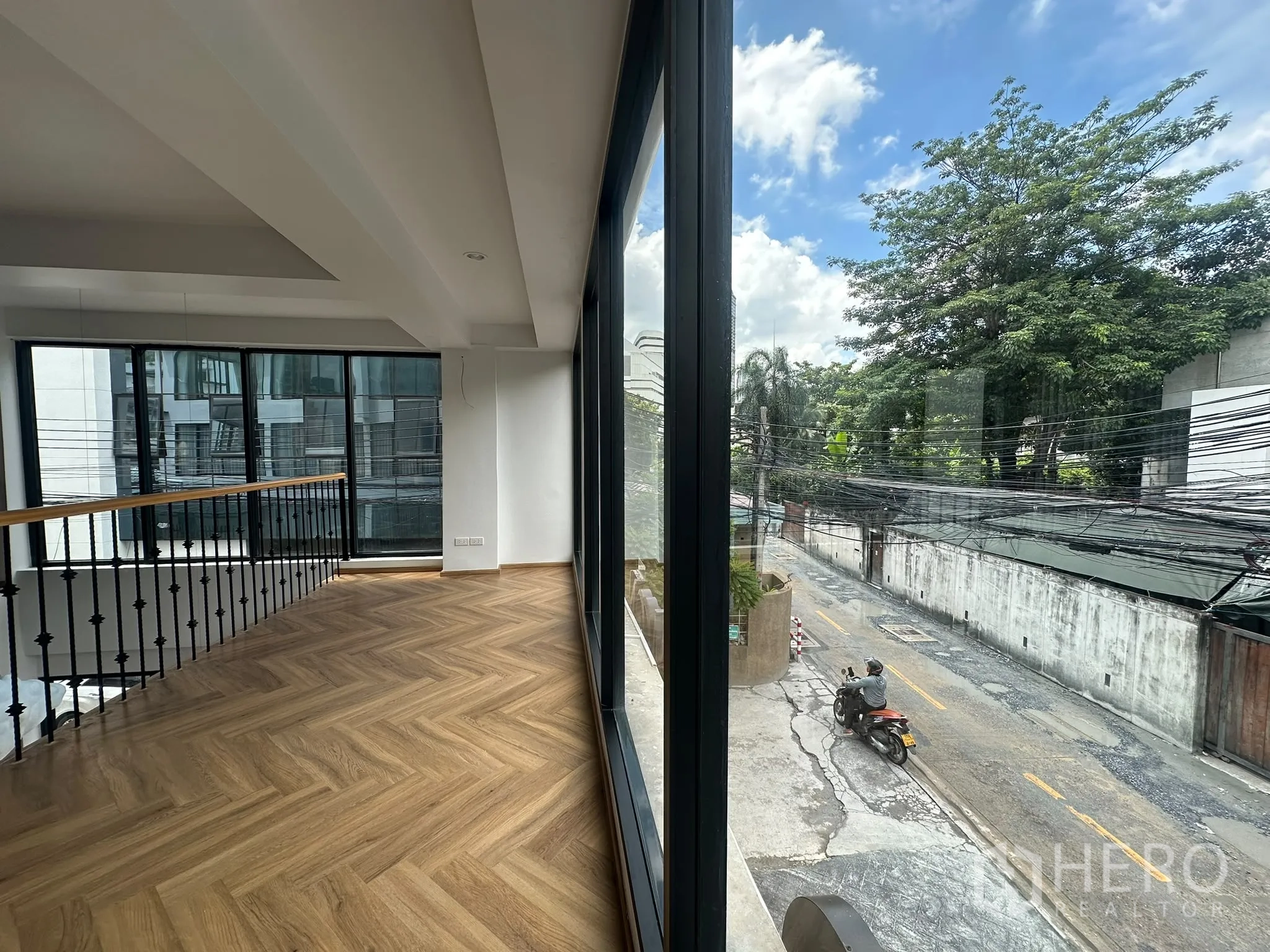 พื้นที่ขายของ for rent in Watthana, Bangkok - โถงยาวริมกระจกบานใหญ่ พื้นไม้ลายก้างปลา มองเห็นถนนและต้นไม้ด้านนอก