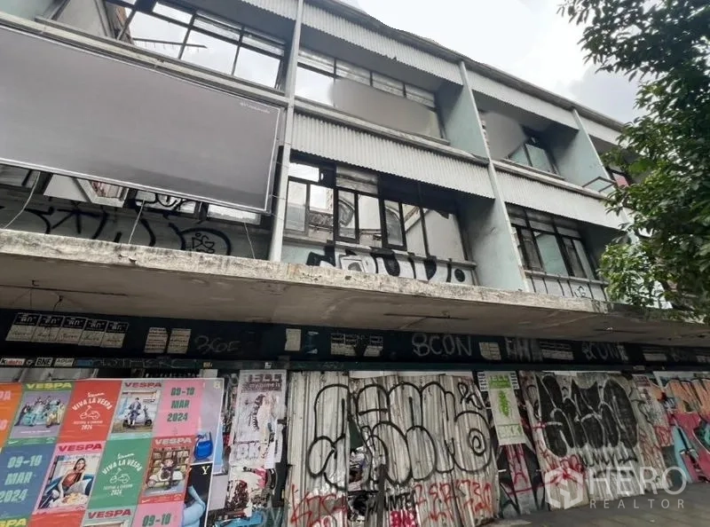 Land for rent in Watthana, Bangkok - Street-facing low-rise block with boarded shopfronts and graffiti in Ekkamai.