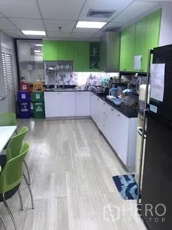 Office Space for rent in Khlong Toei, Bangkok - Office pantry with green cabinets, sink, refrigerator and a small dining table.