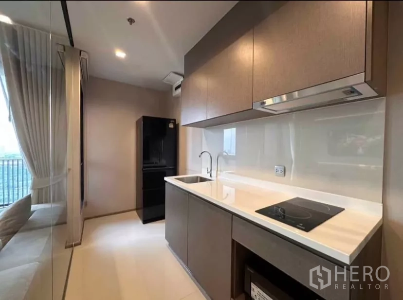 公寓 出租在Chatuchak, Bangkok - 现代廊式厨房，电磁炉、水槽与吊柜，玻璃墙分隔