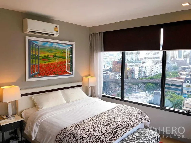 Condominium for rent in Bang Rak, Bangkok - Corner bedroom with king bed and wide windows offering city views.