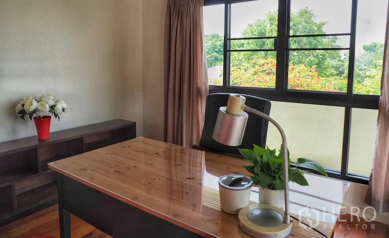 Detached House for rent in Chatuchak, Bangkok - Home office corner with desk by wide windows overlooking trees.