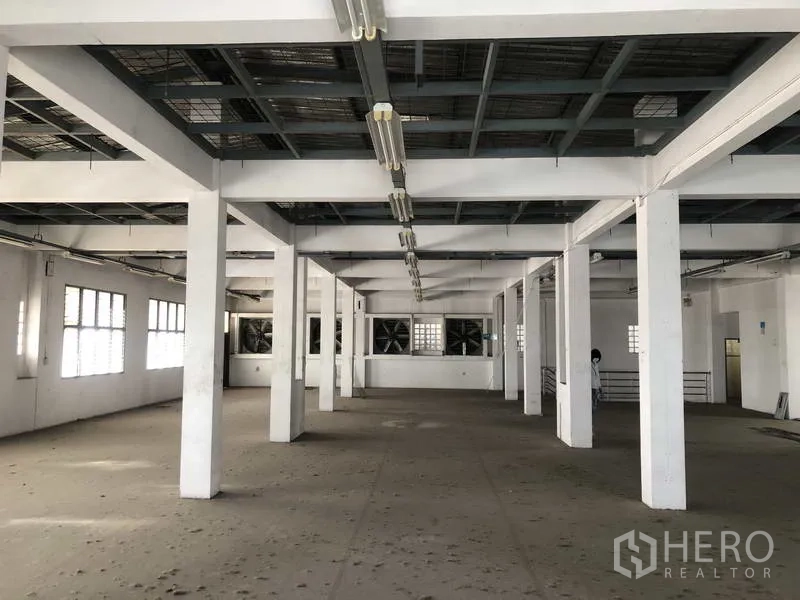 Factory for rent in Prawet, Bangkok - Upper floor workspace with grid ceiling lights and ventilation fans.