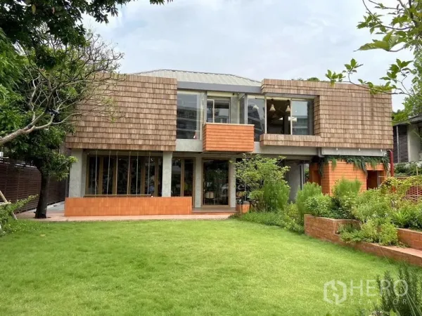 Retail Space for rent in Watthana, Bangkok - Contemporary two-storey retail building with large glass frontage and landscaped lawn.