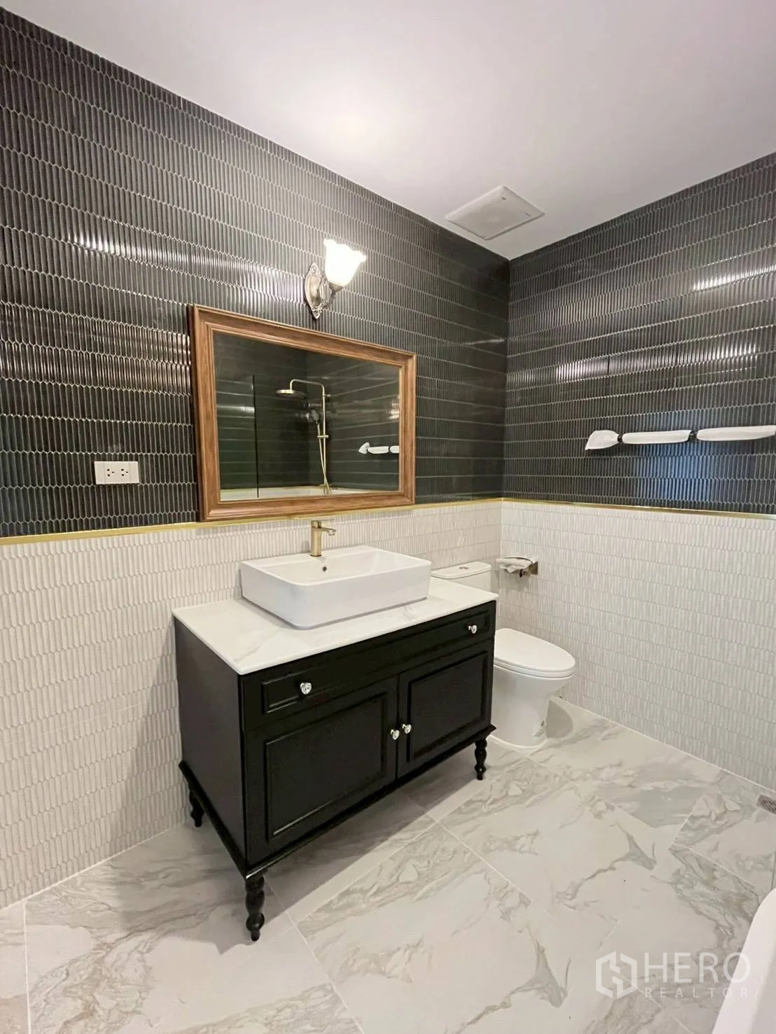 联排别墅 for rent in Khlong Toei, Bangkok - 浴室设洗手台、坐便器与深色点缀墙砖。