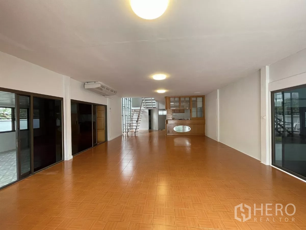 Home Office for rent in Din Daeng, Bangkok - Open hall with orange tiles, built‑in cabinet and stairs leading to the upper floor.