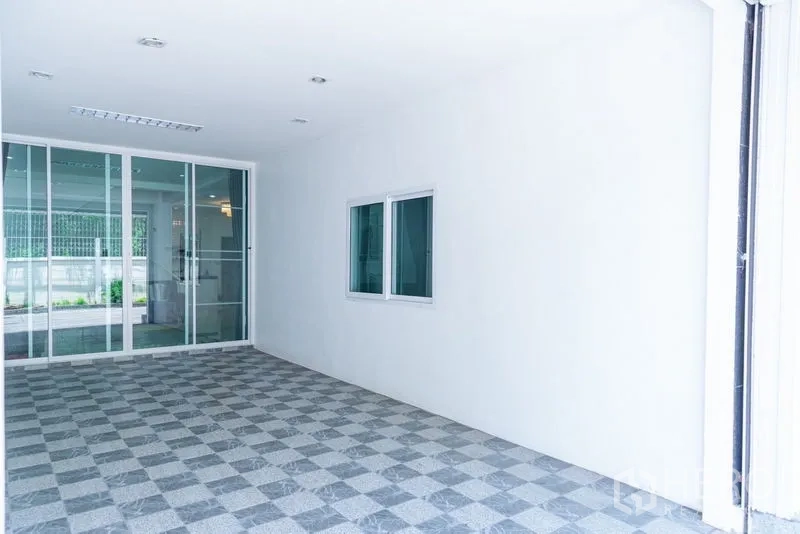 Townhouse for rent in Huai Khwang, Bangkok - Covered carport or terrace with sliding glass doors and checkered floor tiles.