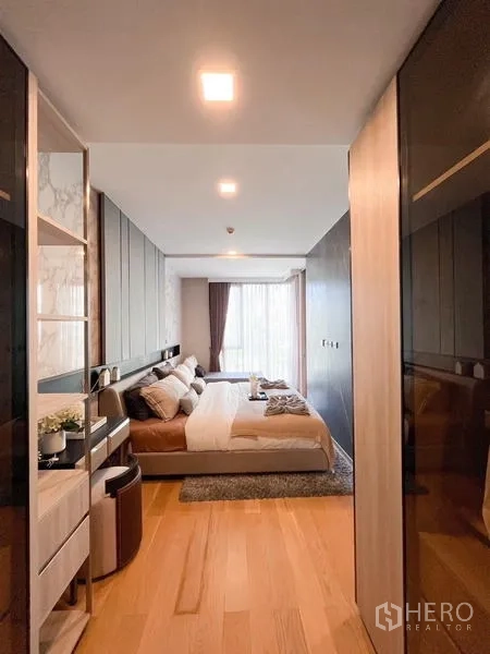 Condominium for rent in Watthana, Bangkok - Hallway view into the bedroom with built-in wardrobes and wooden floors.