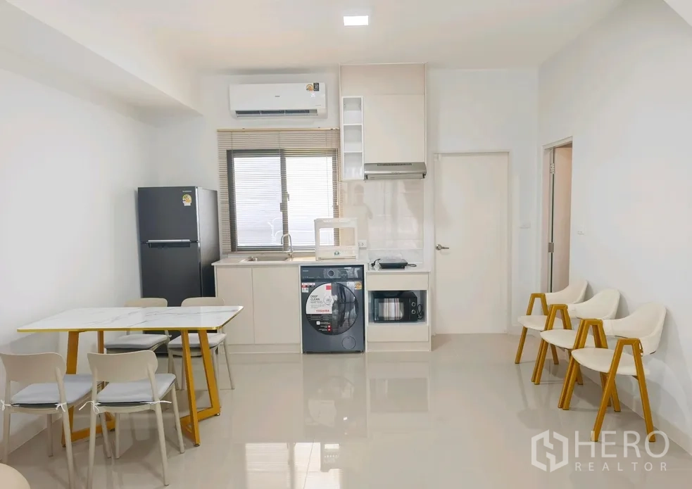 联排别墅 for rent in Bang Phli, Samut Prakan - 开放式餐厨，餐桌、冰箱、水槽、微波炉、洗衣机与橱柜齐全。