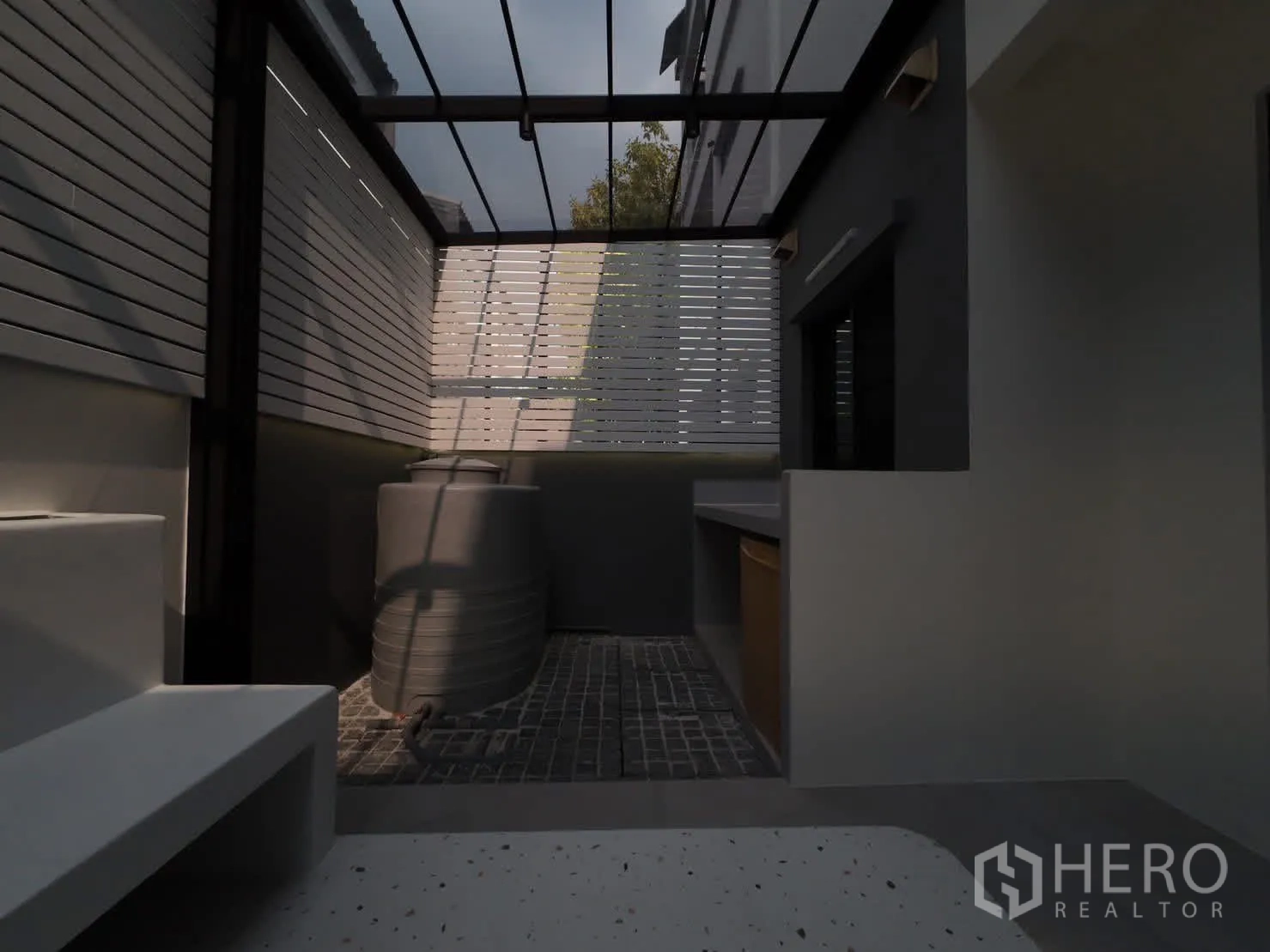 Townhouse for rent or sale in Lat Phrao, Bangkok - Rear service area under polycarbonate roof with water tank.