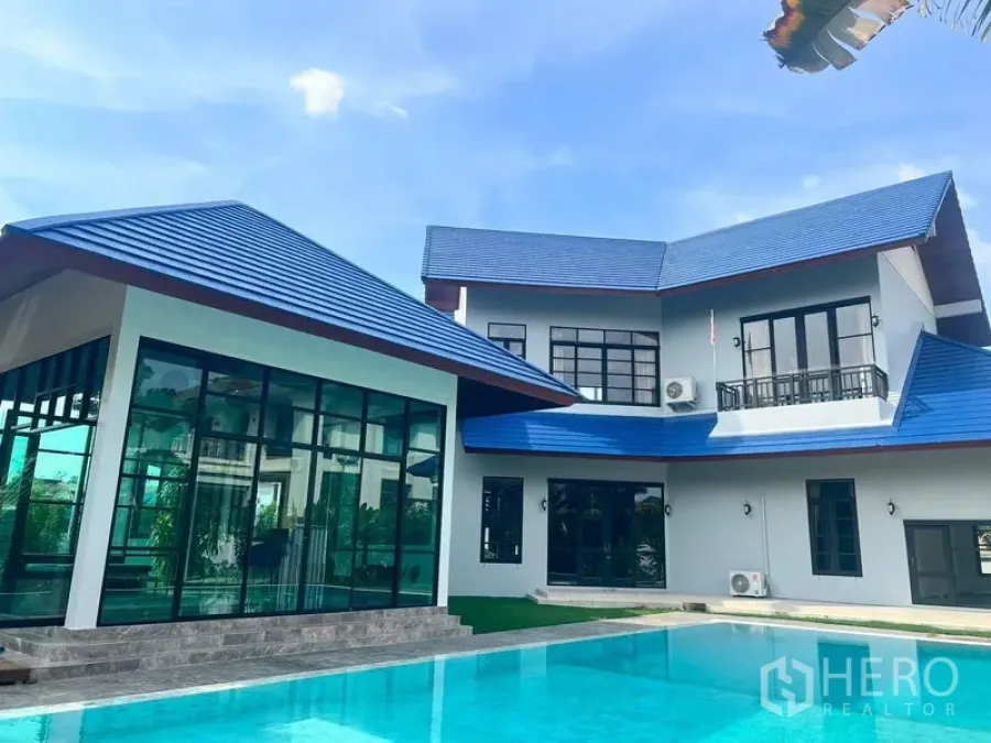 บ้าน ขายในPrawet, Bangkok - ด้านหน้าบ้านร่วมสมัยหลังคาสีน้ำเงินสะท้อนในผิวน้ำสระ