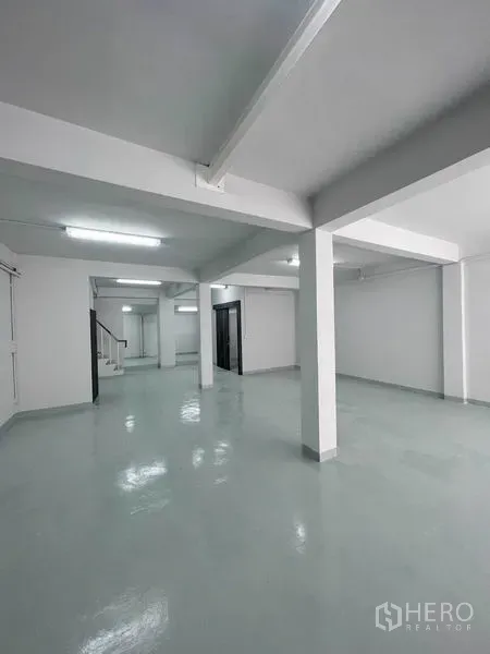 店屋 出租在Khlong Toei, Bangkok - 开放式楼层，环氧地坪光亮，结构立柱与明亮日光灯。