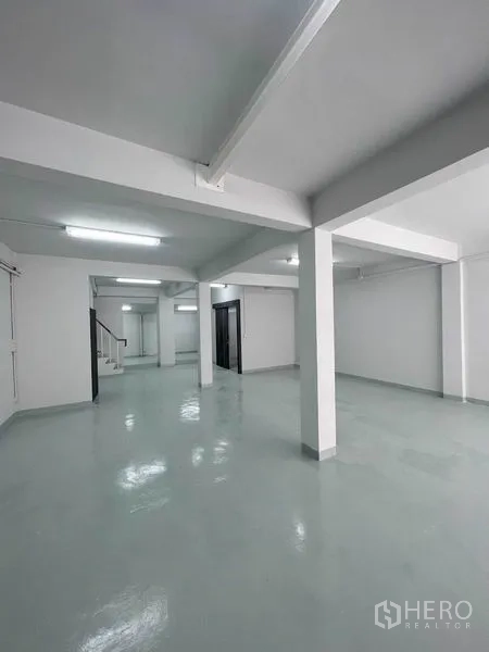 店屋 出租在Khlong Toei, Bangkok - 开放式楼层，环氧地坪光亮，结构立柱与明亮日光灯。