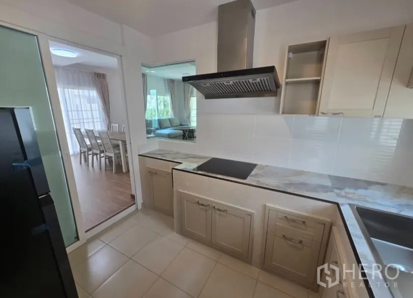 独立式住宅 for rent in Bang Phli, Samut Prakan - 封闭式厨房，设电磁炉、抽油烟机、仿石台面与瓷砖墙面。
