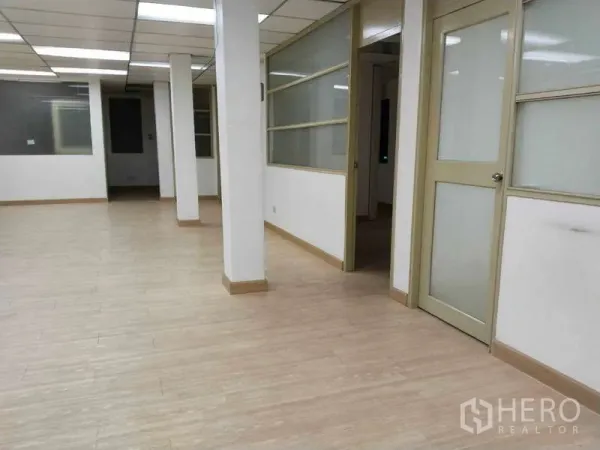 办公空间 出租在Bang Na, Bangkok - 大面积工作区，设支柱与侧面滑动玻璃隔间。