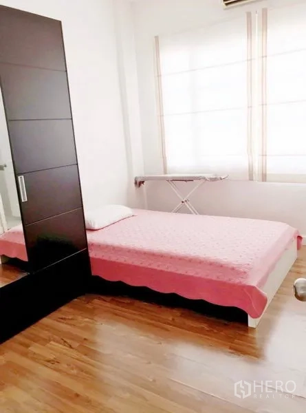 联排别墅 出租在Prawet, Bangkok - 次卧配单人床，木地板，大窗与衣柜。