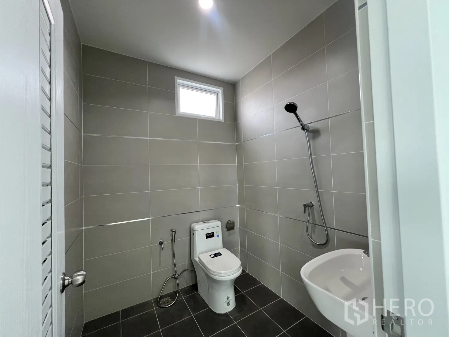 Warehouse for rent in Mueang Samut Prakan, Samut Prakan - Second bathroom with shower set, wall tiles and compact basin.