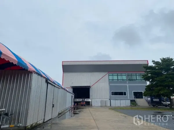 Factory for rent or sale in Lam Luk Ka, Pathum Thani - Industrial factory exterior in Lam Luk Ka with a wide driveway and loading bay.
