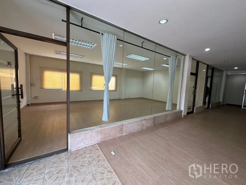 คลังสินค้า ให้เช่าในSuan Luang, Bangkok - ห้องกั้นกระจกสไตล์สตูดิโอ มีผ้าม่านและไฟดาวน์ไลท์ตามทางเดิน