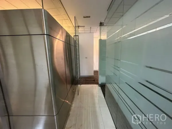 Office Space for rent - Hallway with frosted glass partitions and stainless-steel cladding leading to private offices.