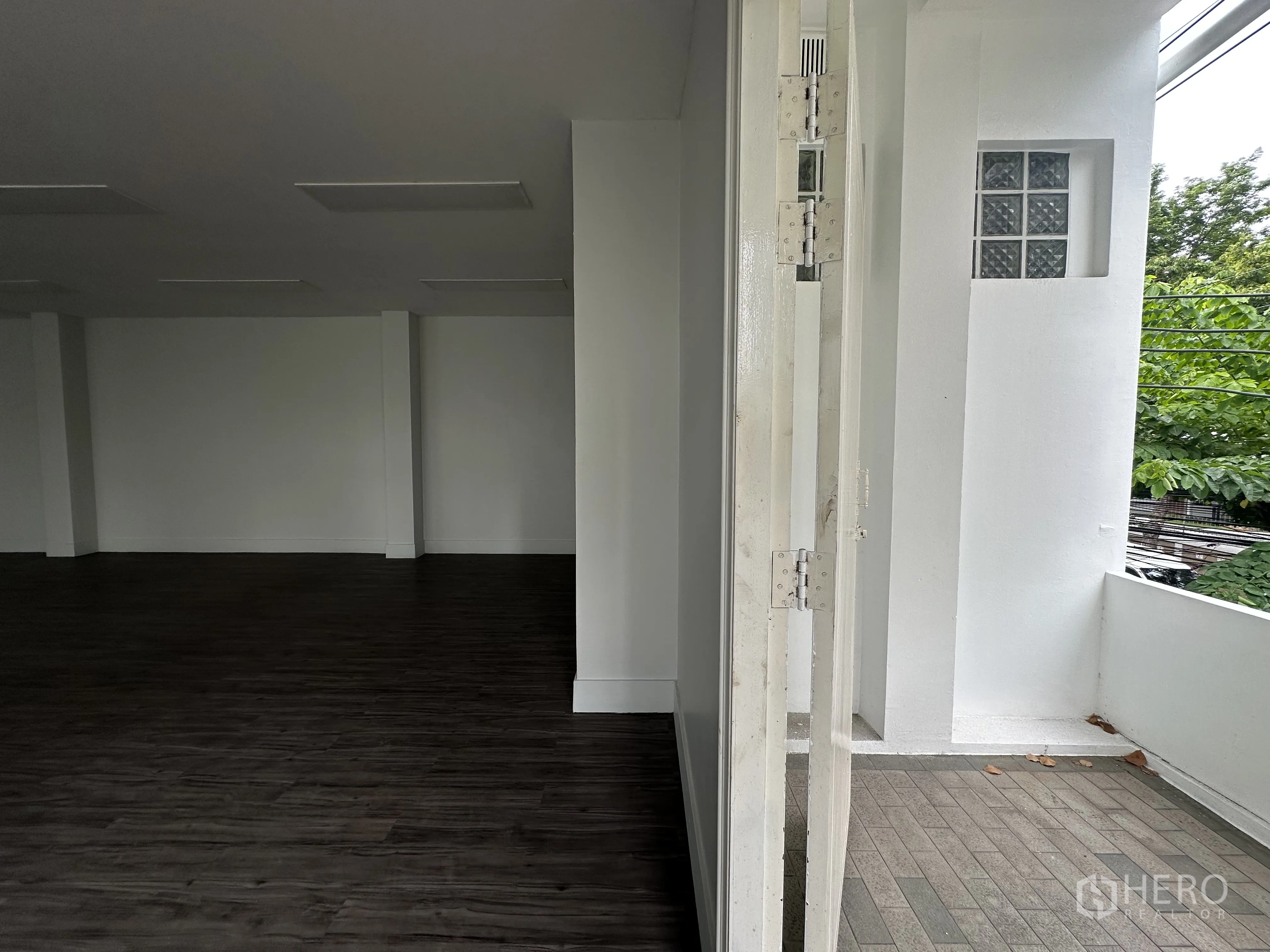 Retail Space for rent in Bang Rak, Bangkok - View from interior to the tiled balcony and open doorway.