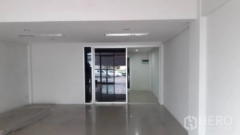 办公空间 出租在Bueng Kum, Bangkok - 一层开放式办公区，滑动玻璃门面向街边停车位。