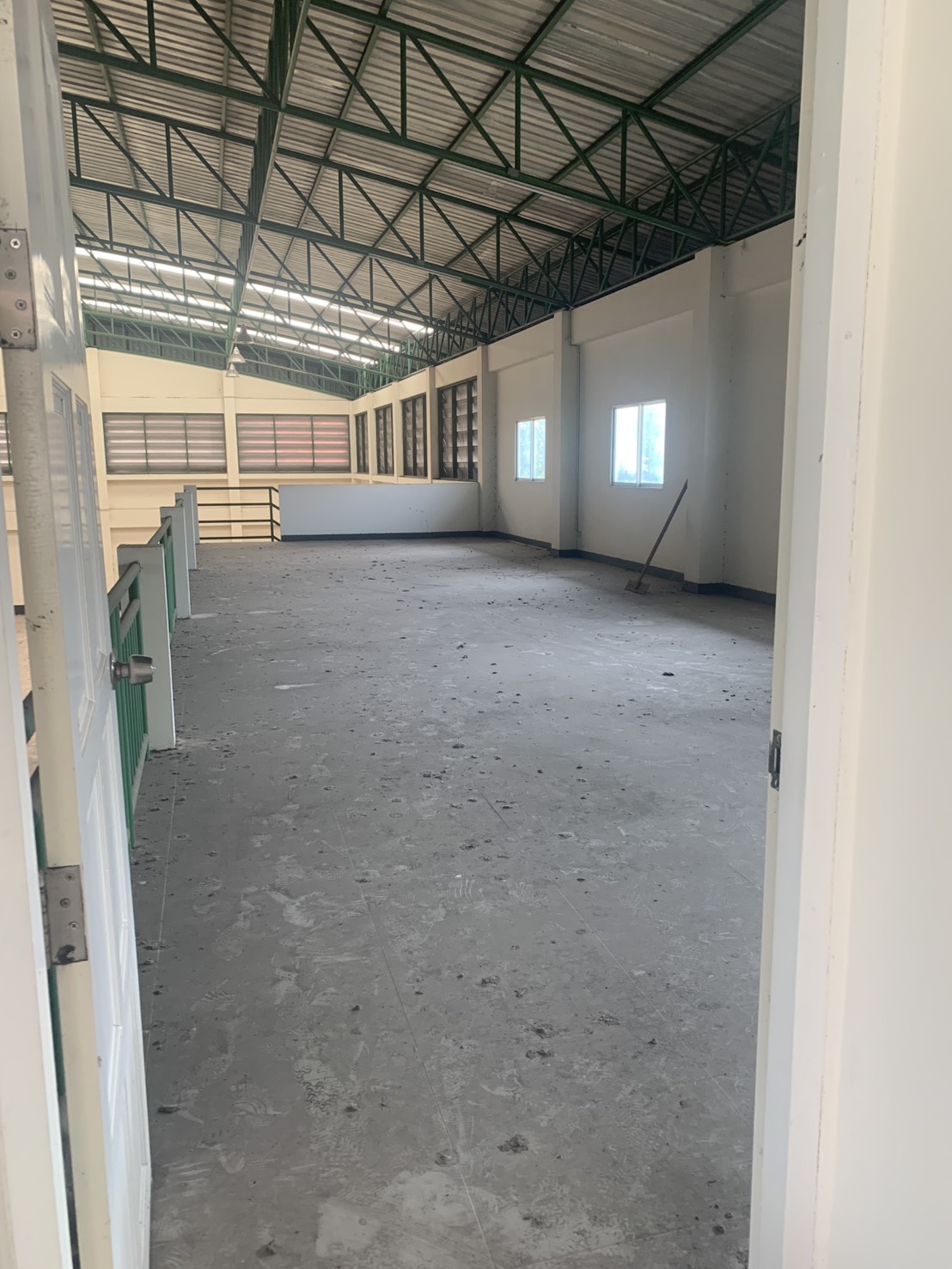 Warehouse for rent in Lam Luk Ka, Pathum Thani - Spacious mezzanine floor beneath green steel trusses inside a high-clearance warehouse.