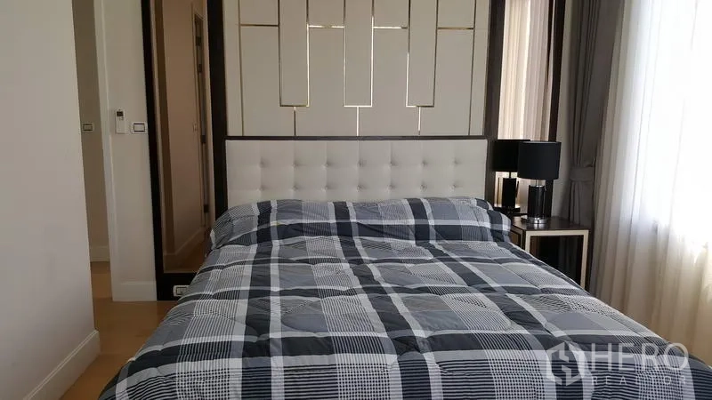 公寓 出租在Chatuchak, Bangkok - 次卧铺格纹床品，床头灯与柔和采光。
